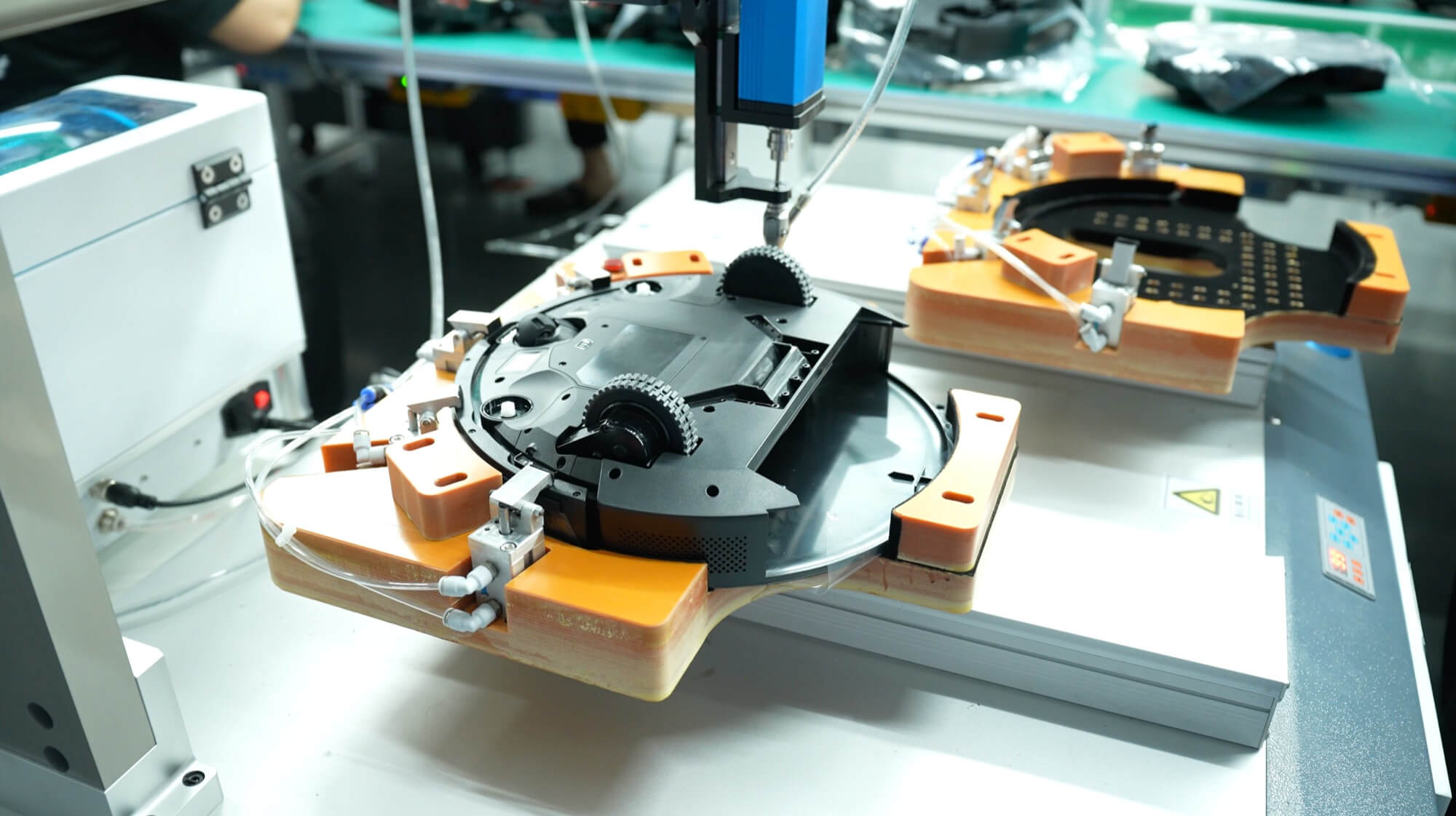 automated-gluing-machine-robot-vacuum-chassis Automated multi-axis gluing machine dispensing sealant on a robot vacuum chassis